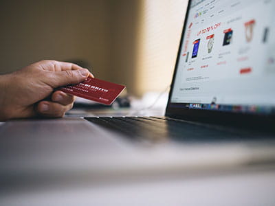 Black and Gray Laptop Computer With Turned-on Screen Beside Person Holding Red Smart Card in Selective-focus Photography