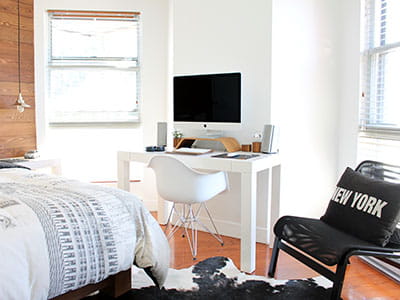 white wooden desk near bed inside the room