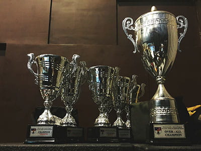 several silver and gold trophies on wooden surface